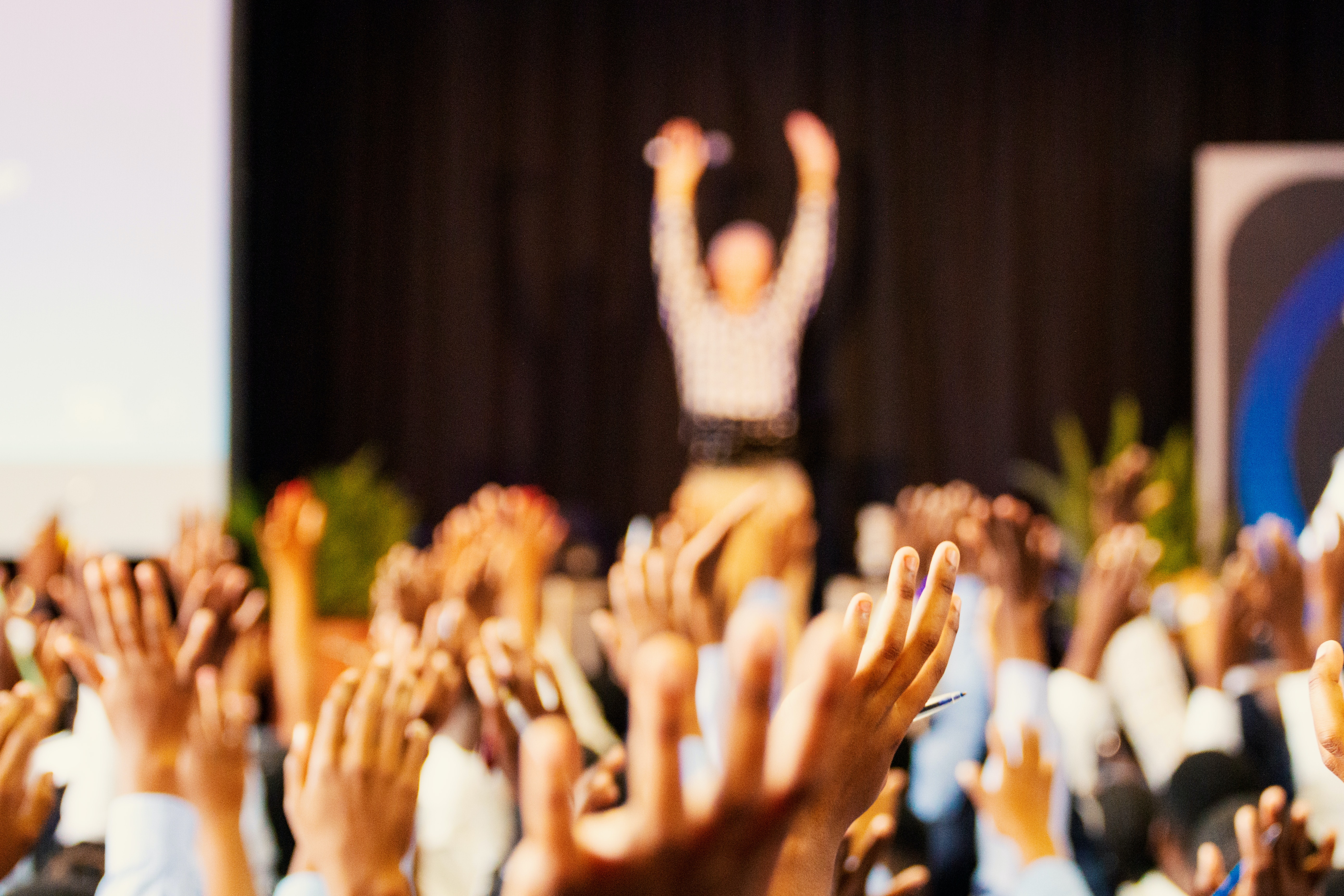 Guest Speaking Service Image: A woman on stage speaking to and engaging a crowd